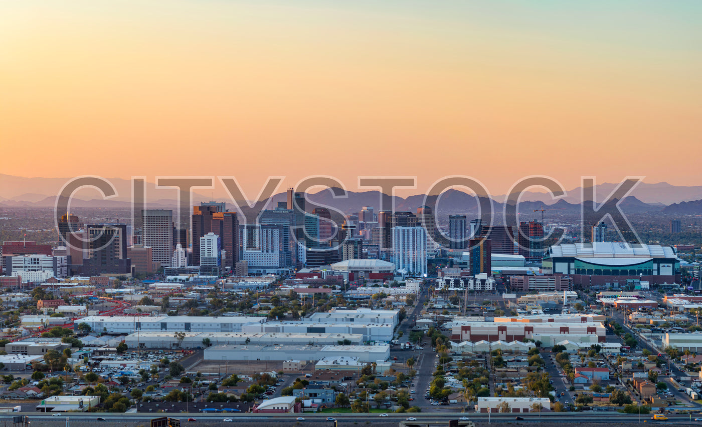 Phoenix skyline at sunset with vivid orange hues and city lights