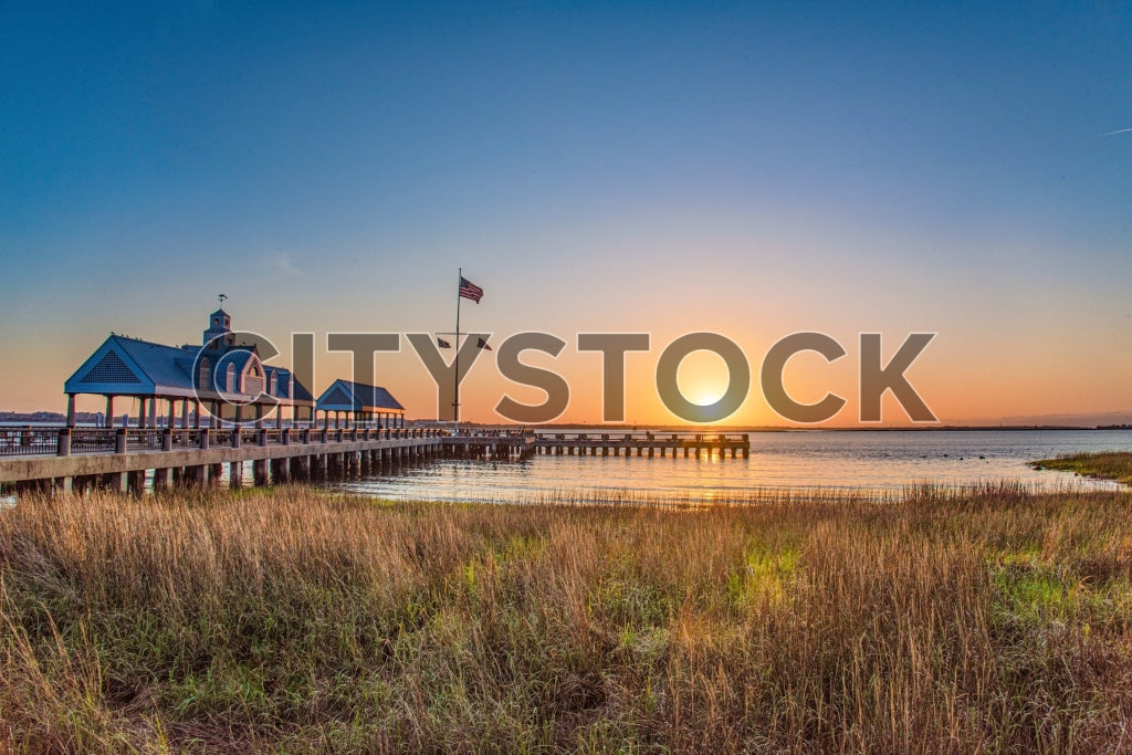 Sunset at historic Charleston pier with wavy grass foreground