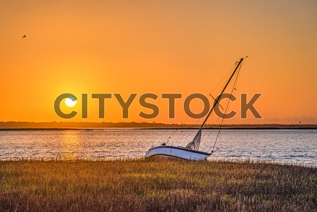 Golden sunset and stranded sailboat in Charleston, SC