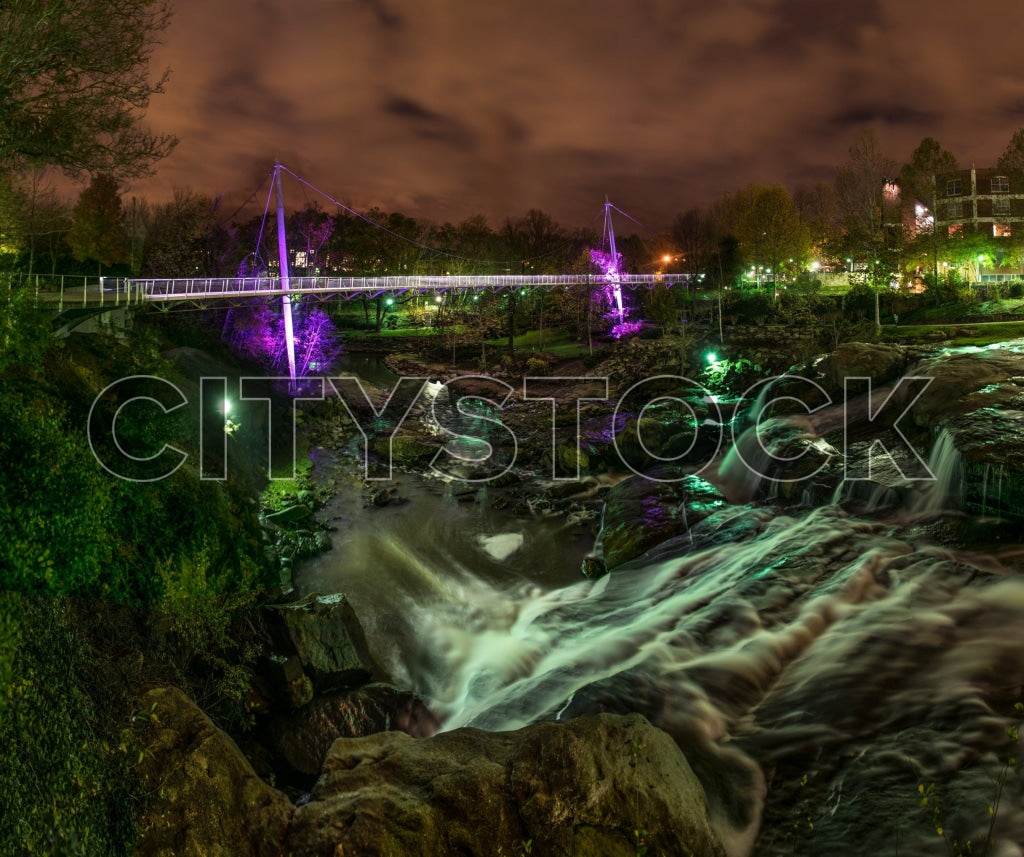 Vivid night view of pedestrian bridge over waterfall in Greenville, SC