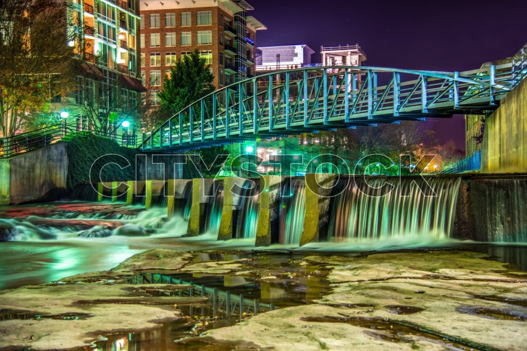 Greenville SC illuminated bridge over waterfall at night