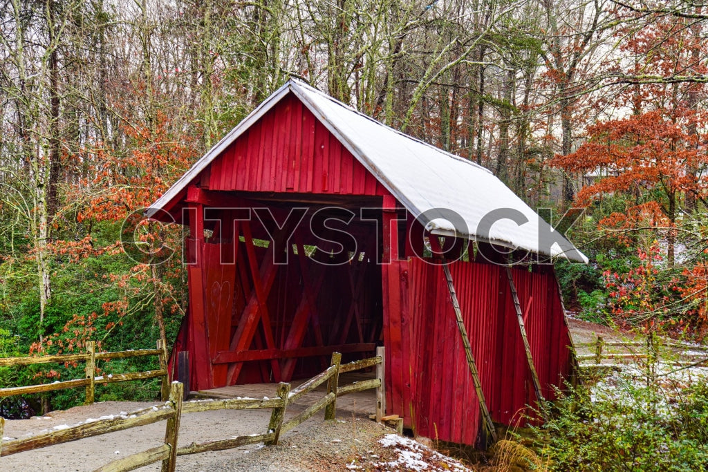 Rustic red covered bridge with autumn foliage and snow in Greenville, SC