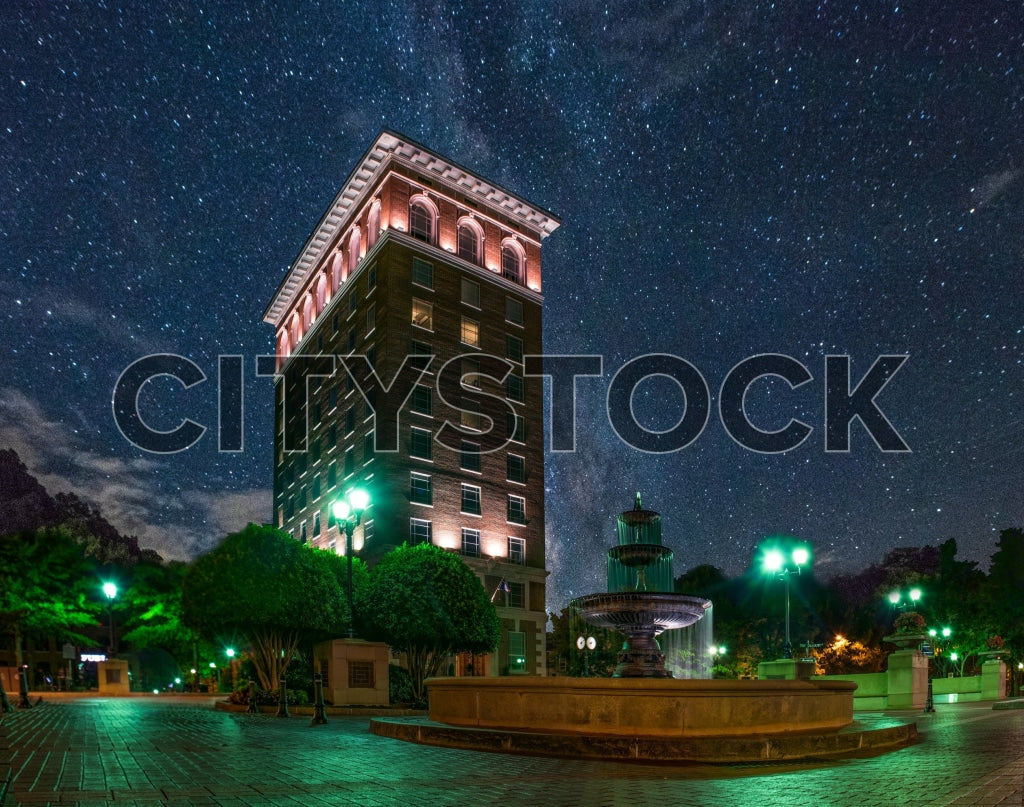 Night view of a historic building and fountain under starry sky in Greenville