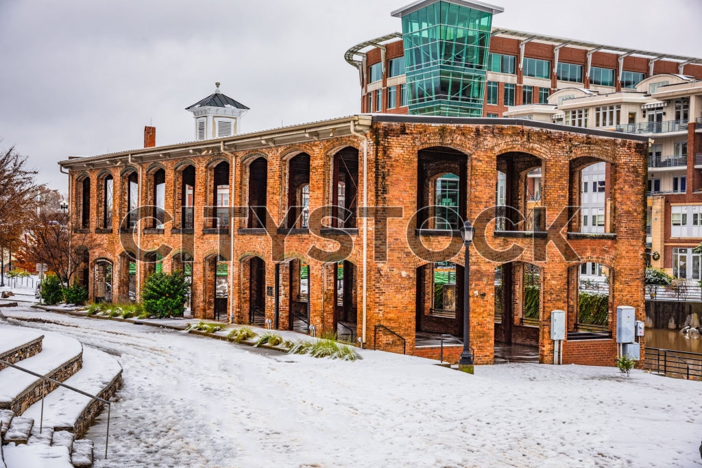 Historic brick building in Greenville with snow and modern backdrop