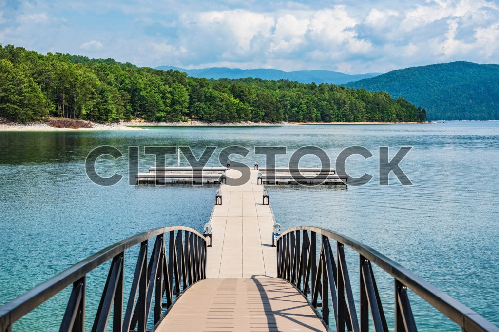 Wooden pathway leading to a tranquil lake with mountain backdrop