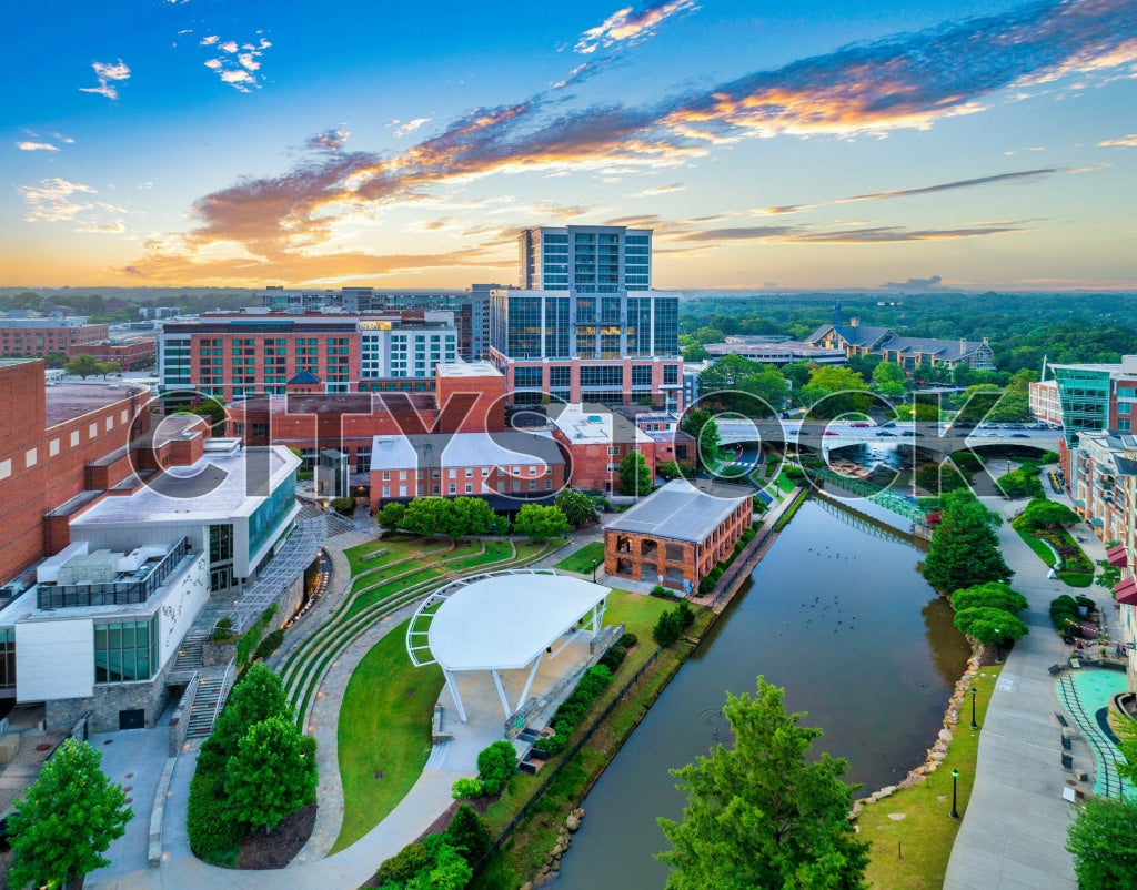 Aerial view of Greenville at sunrise, showing river and modern buildings