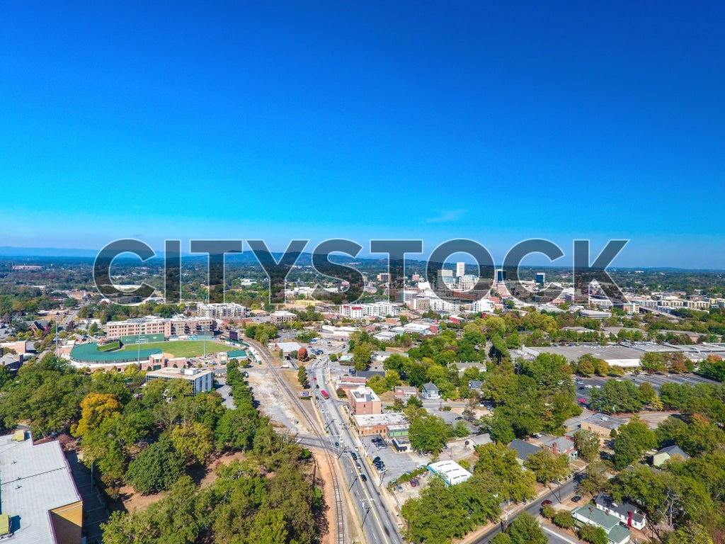 Aerial cityscape view of Greenville, SC under bright blue sky