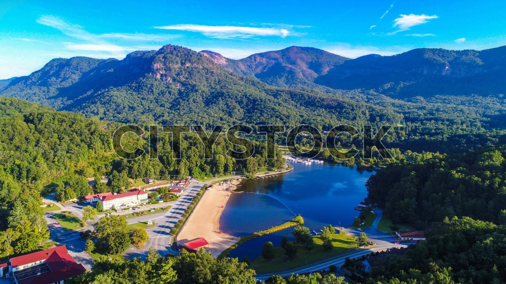 Aerial view of Lake Lure, mountains and lush forest under blue sky