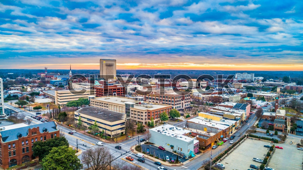 Sunset illuminates Spartanburg downtown in vibrant colors from an aerial view