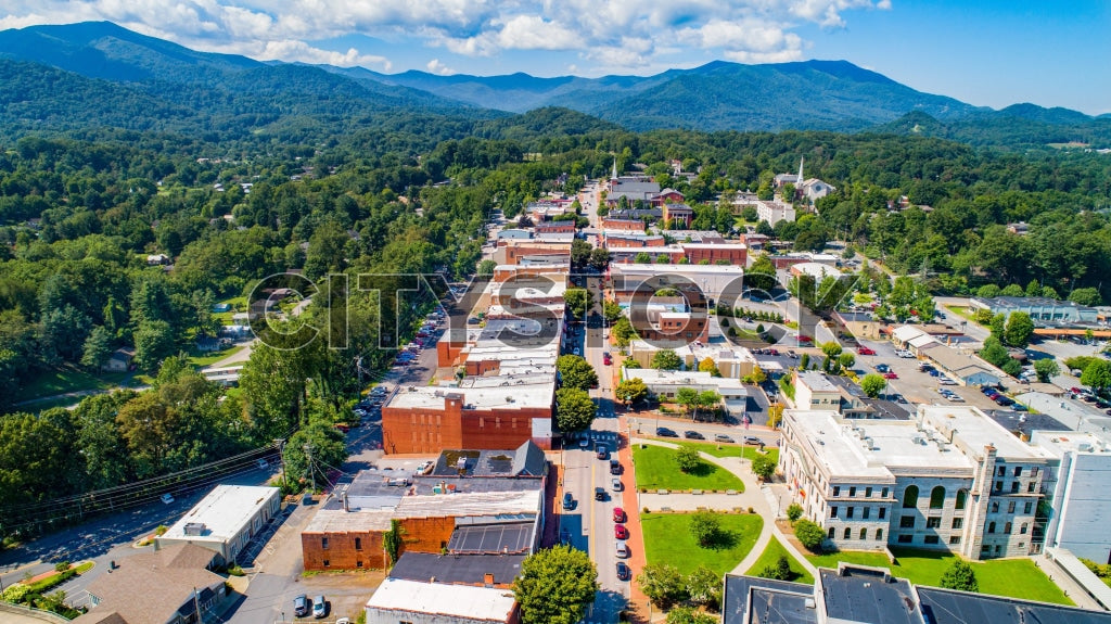 Aerial view of Waynesville, NC surrounded by mountains under blue sky